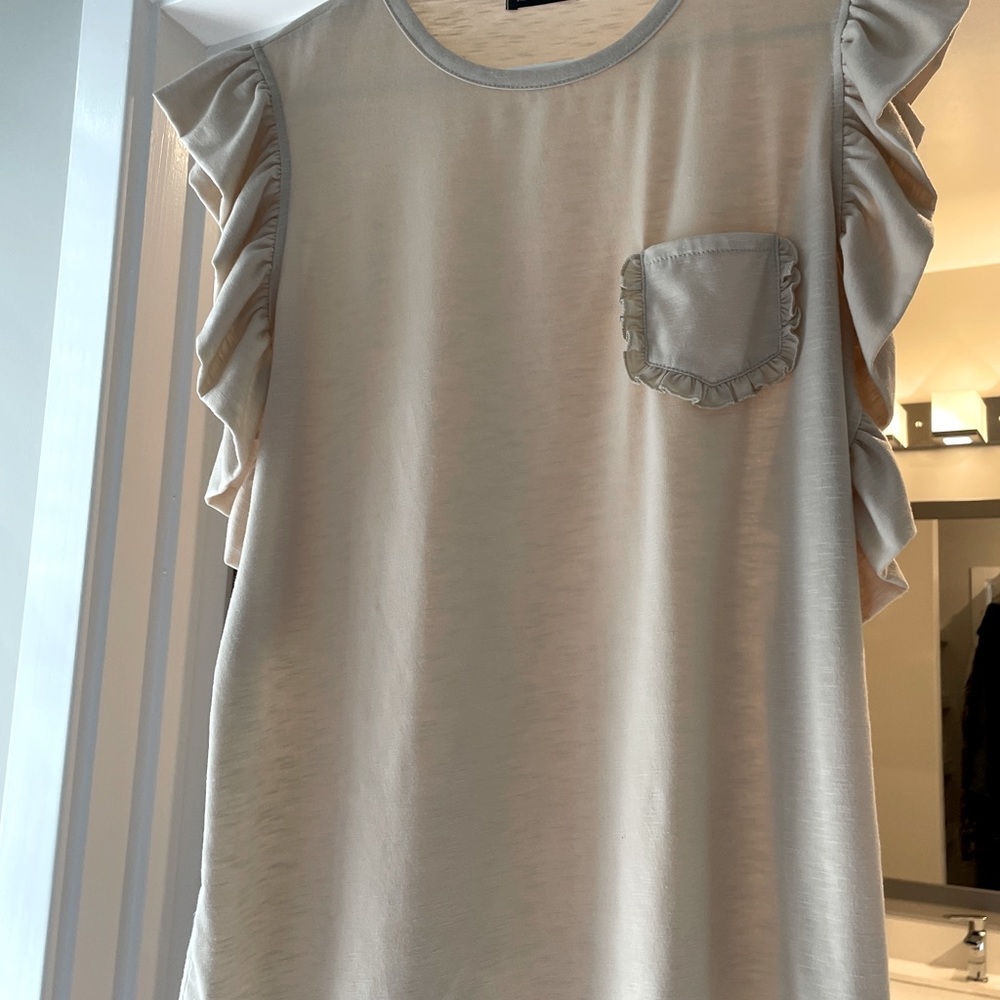 Cream color t top with ruffle sleeves. Soft and comfortable. Never worn